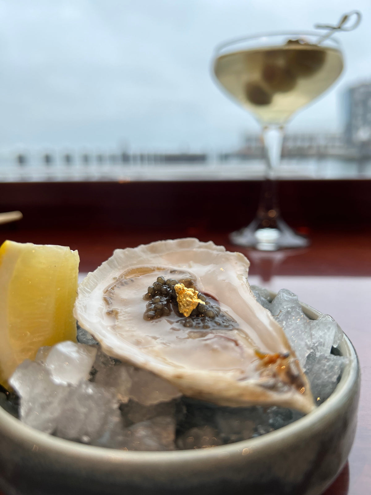 Oyster topped with caviar beside a martini